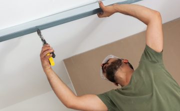 Worker building plasterboard wall.
